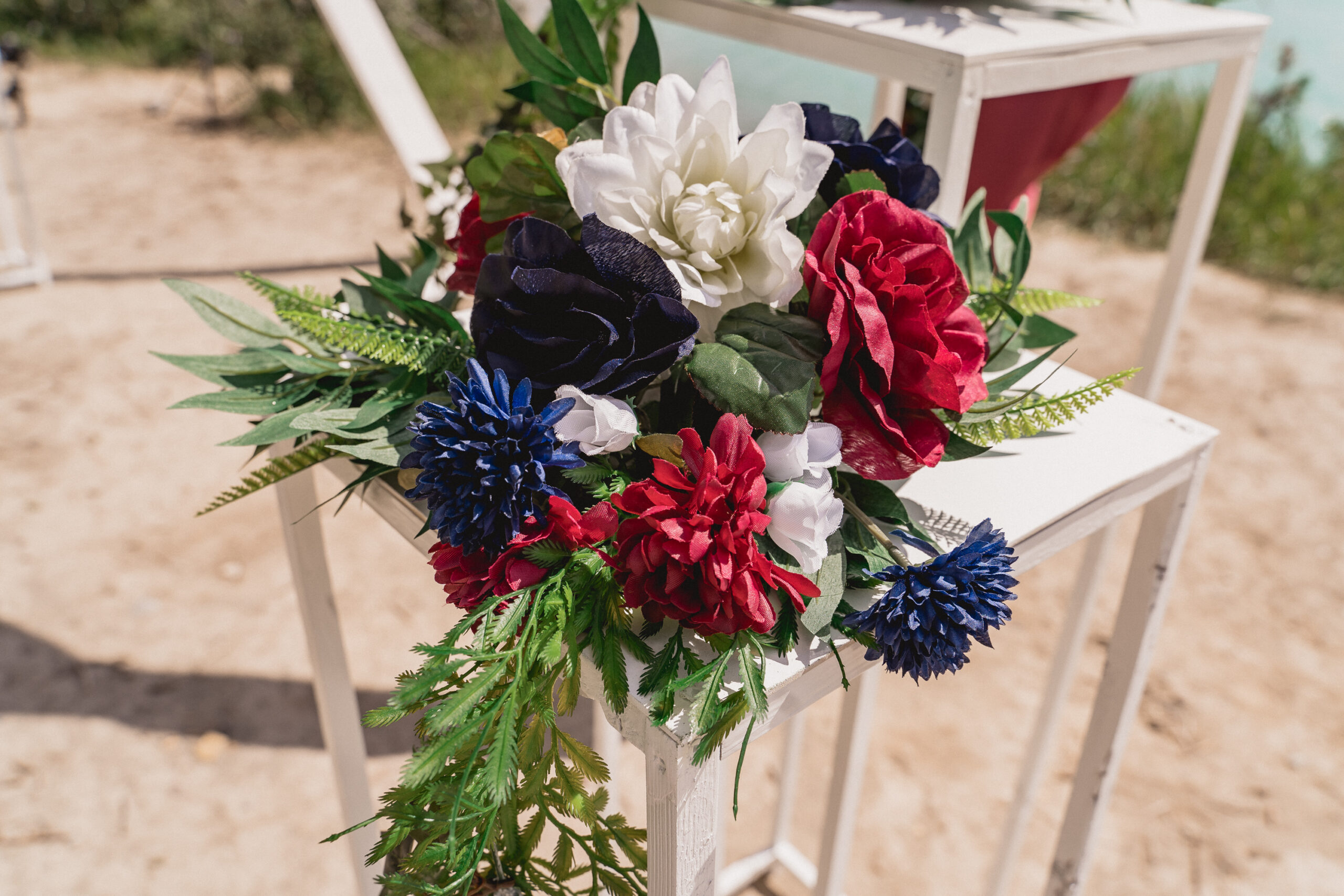 Wedding ceremony decor with red flowers and cobalt blue flowers