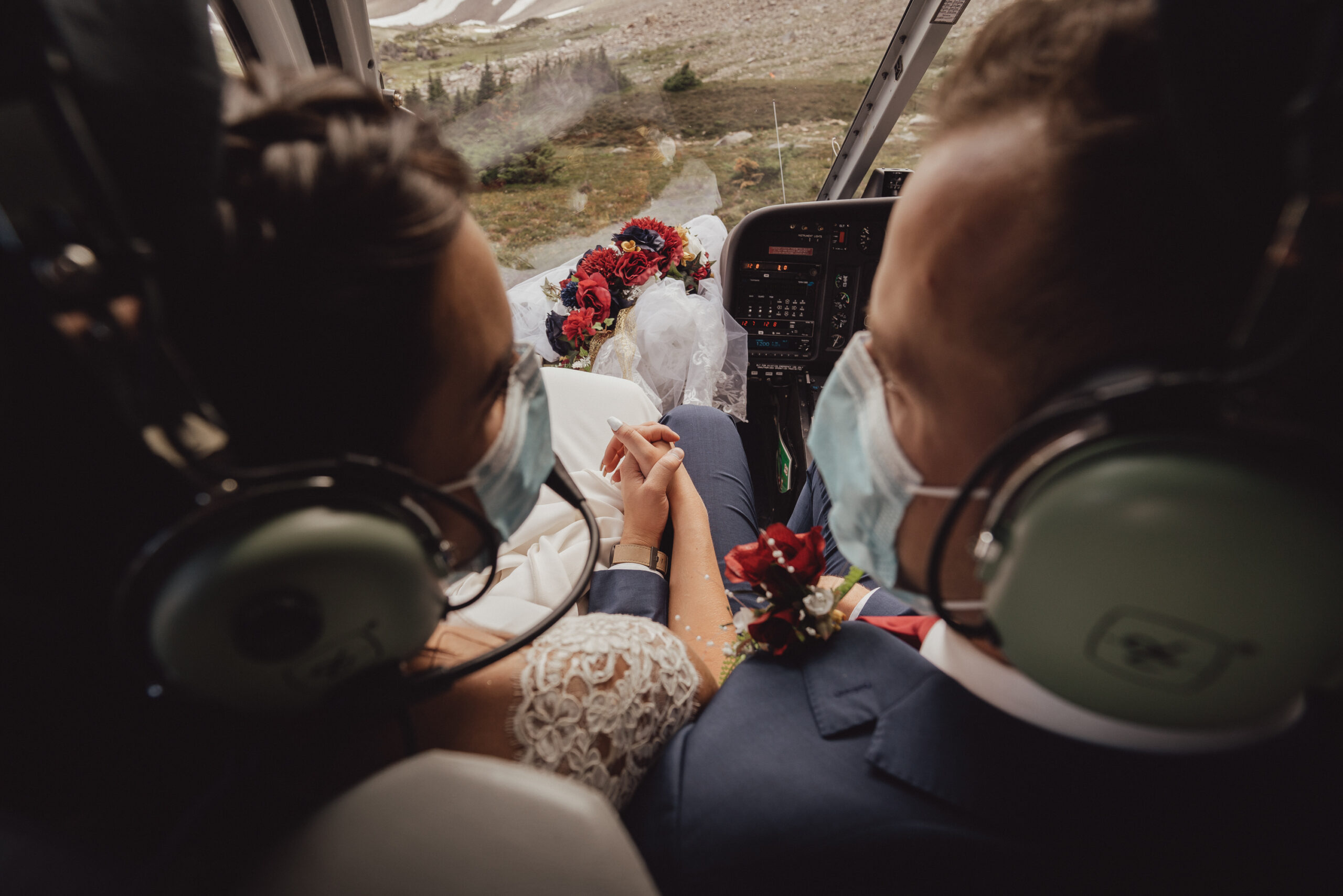Bride and Groom holding hands in a helicopter