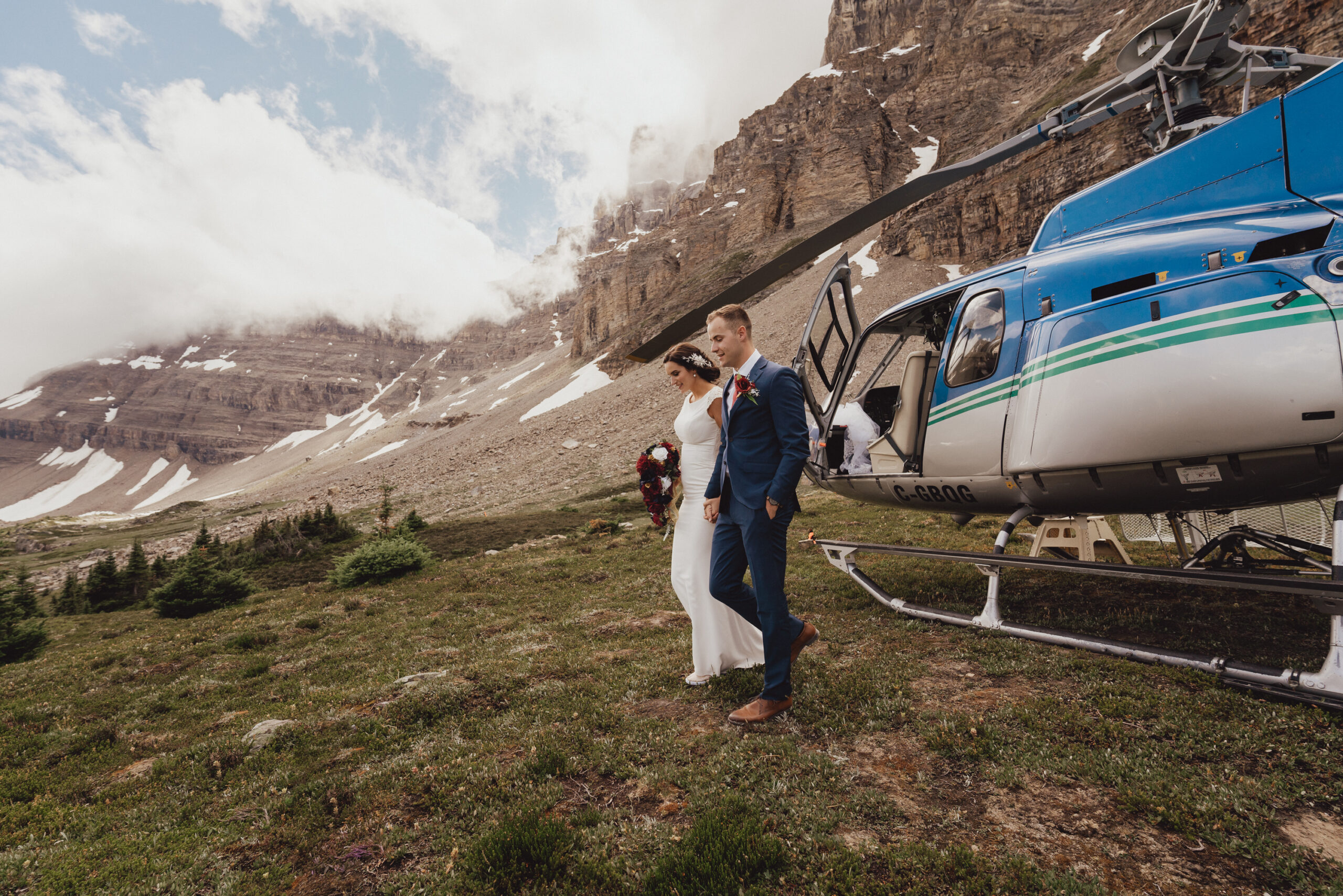 Bride and groom getting off of helicopter