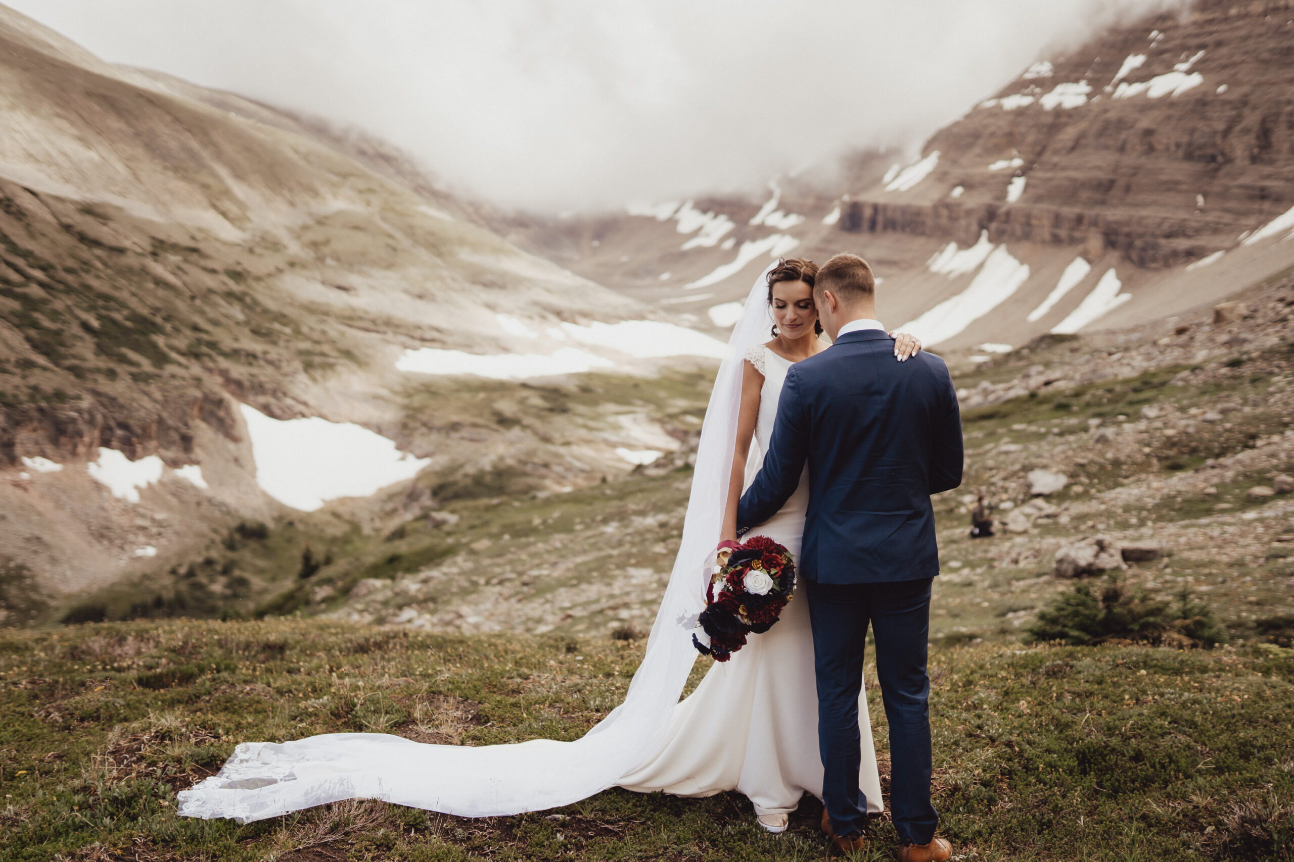 Bride and groom kissing in front of Rocky Mountain landscape