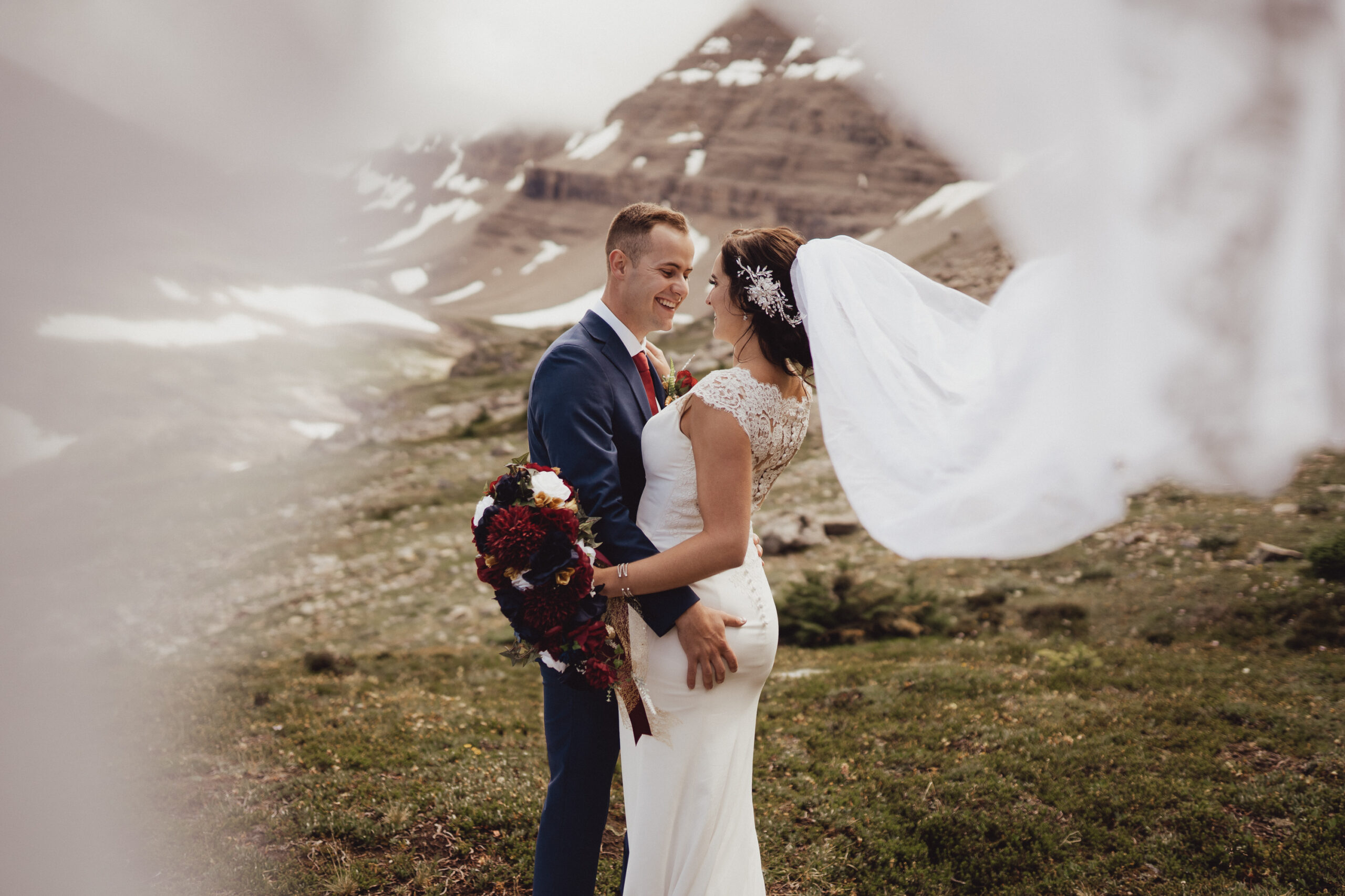 Bride and groom kissing in front of Rocky Mountain landscape