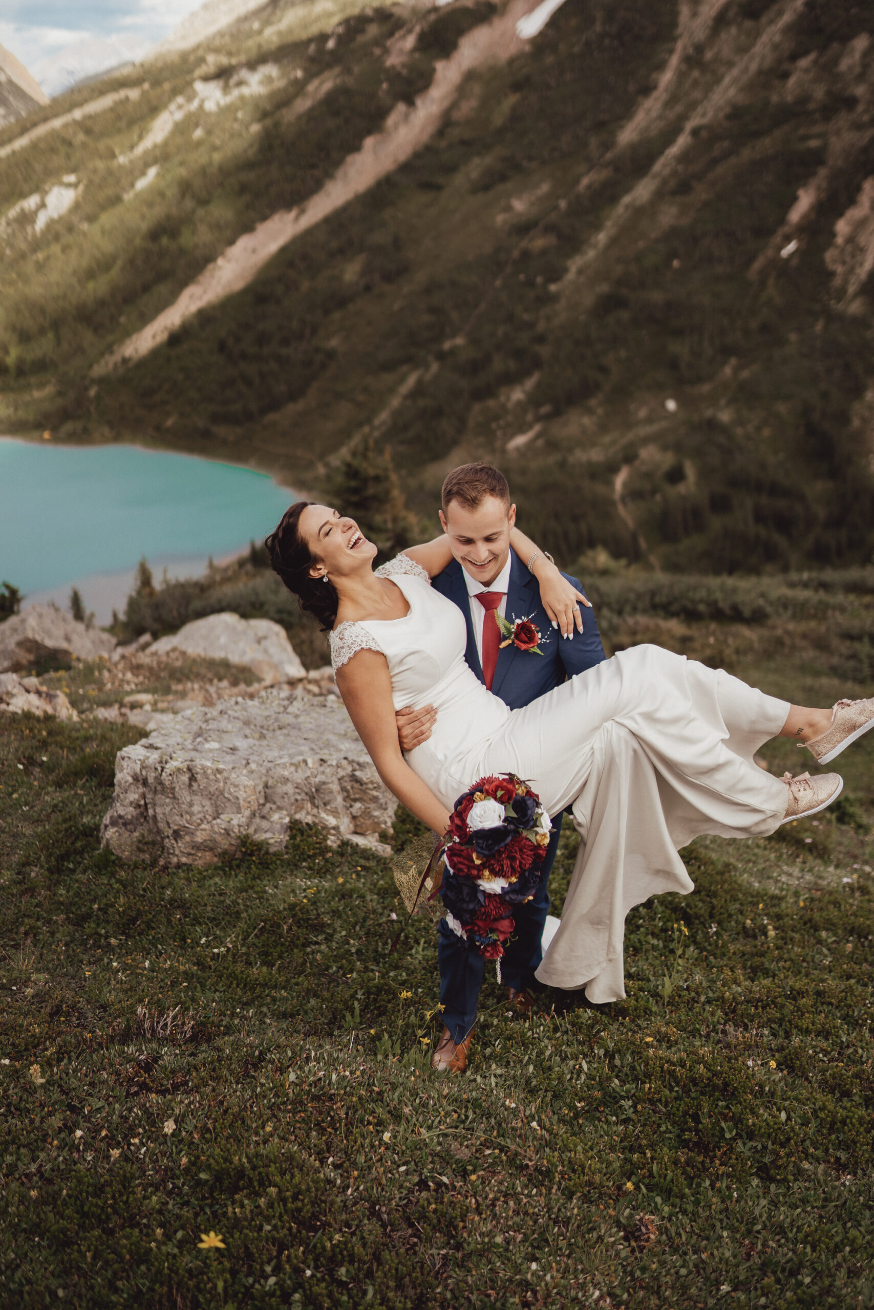 Bride and groom laughing in front of Rocky Mountain landscape