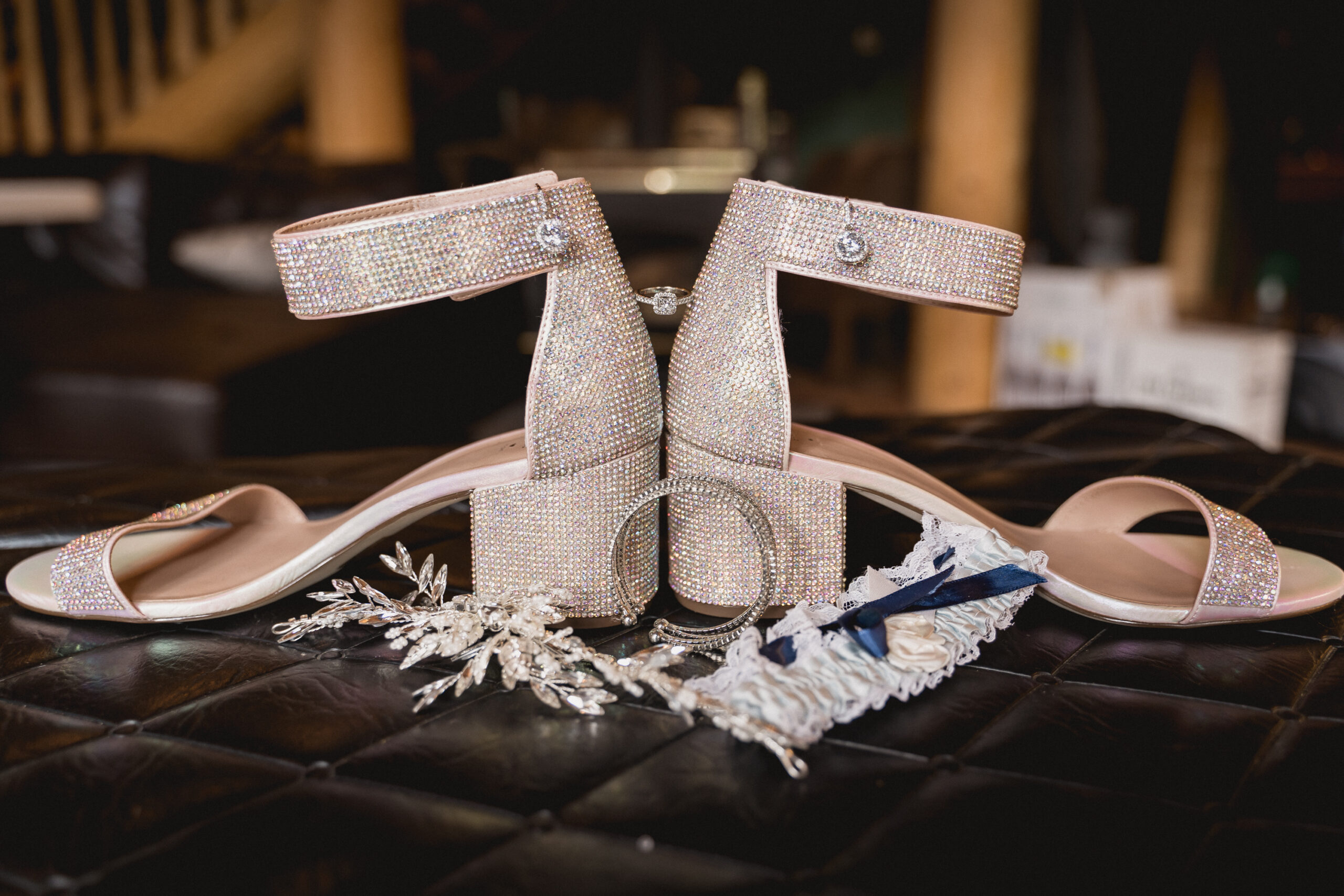 Sparkling silver wedding shoes with chunky heel and sparkling hair brooch on dark velvet