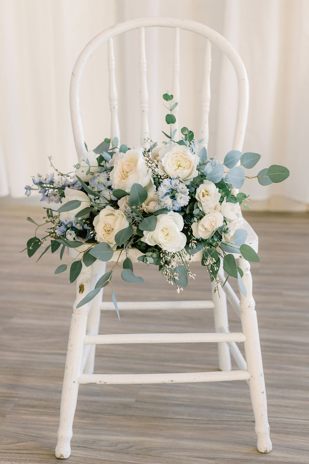 White and light blue wedding bouquet on vintage white chair