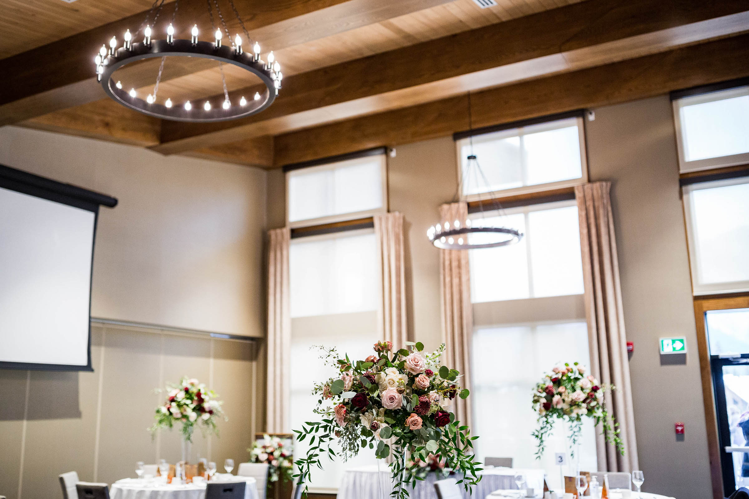 Chandeliers over wedding table with tall flower center pieces