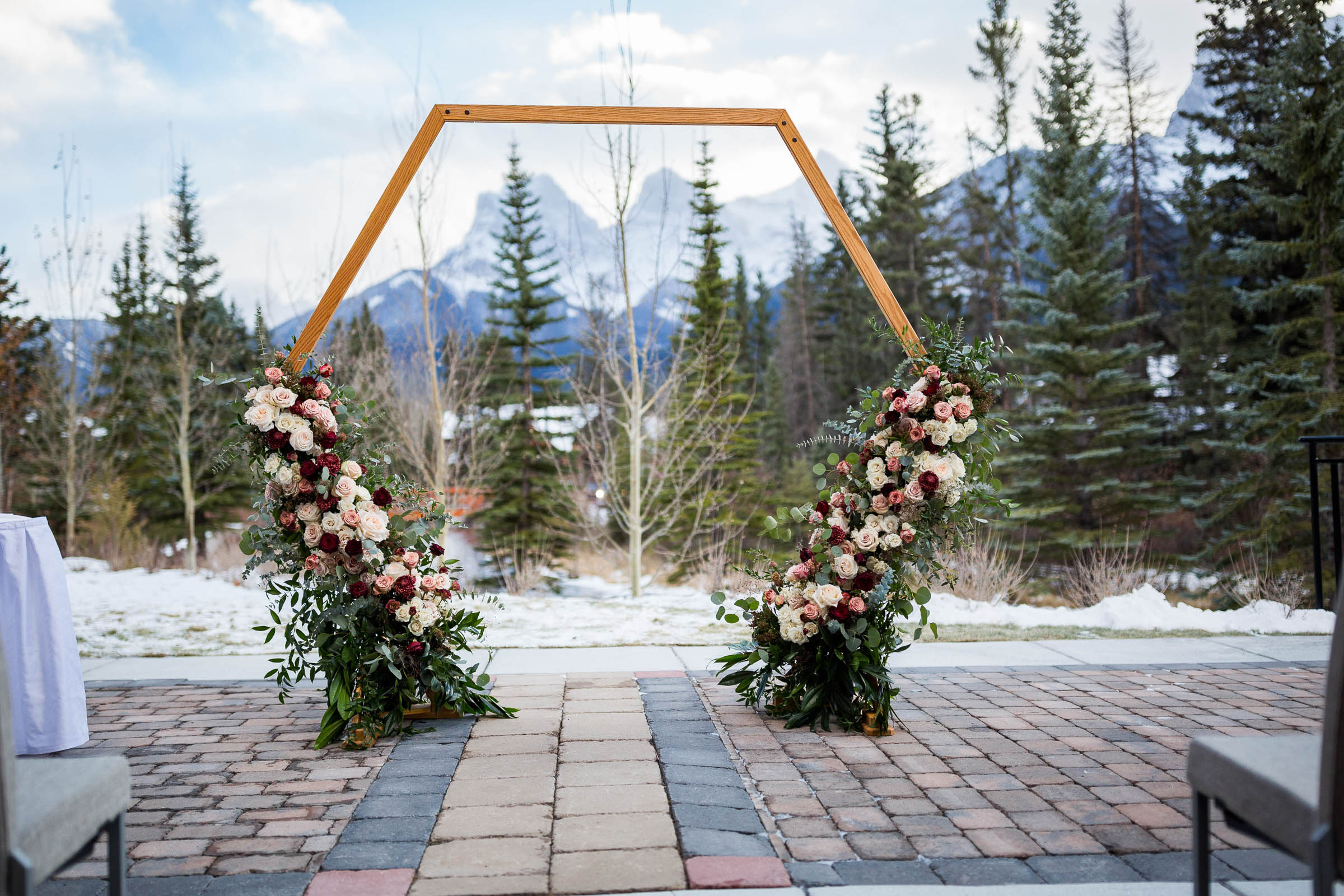 Geometric wedding ceremony backdrop with flowers cascading from the bottom up