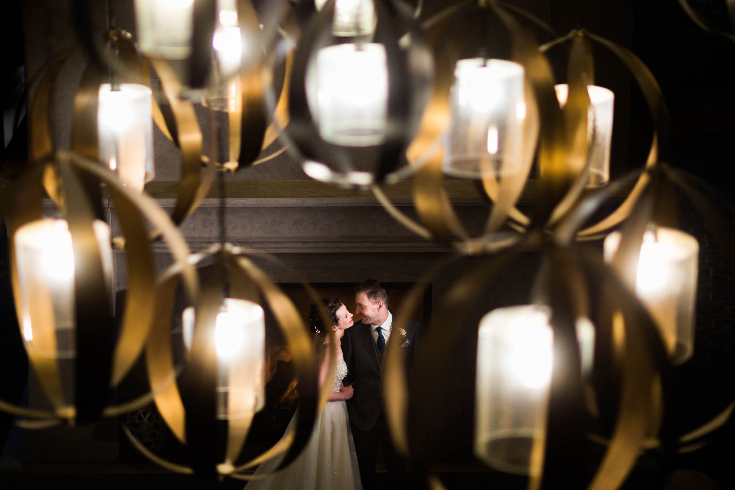 Peek of bride and groom through chandelier