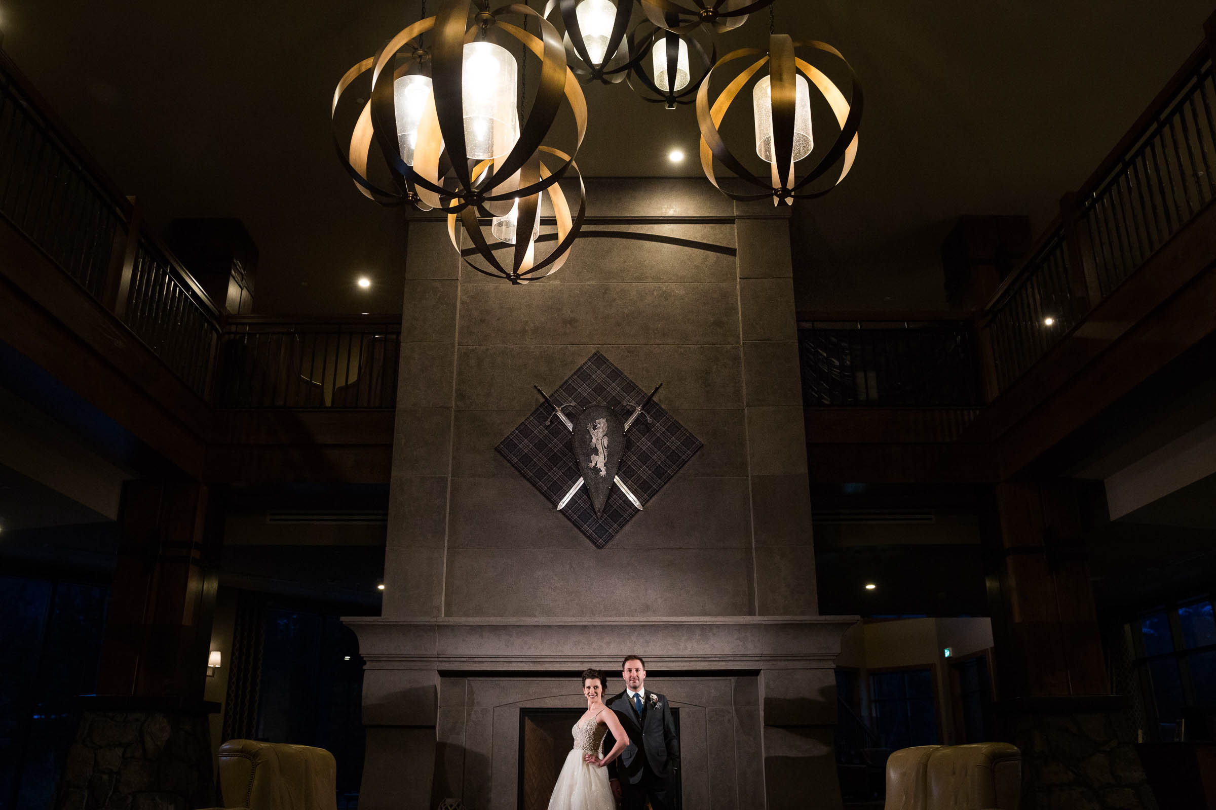 Bride and groom in front of dramatic fireplace