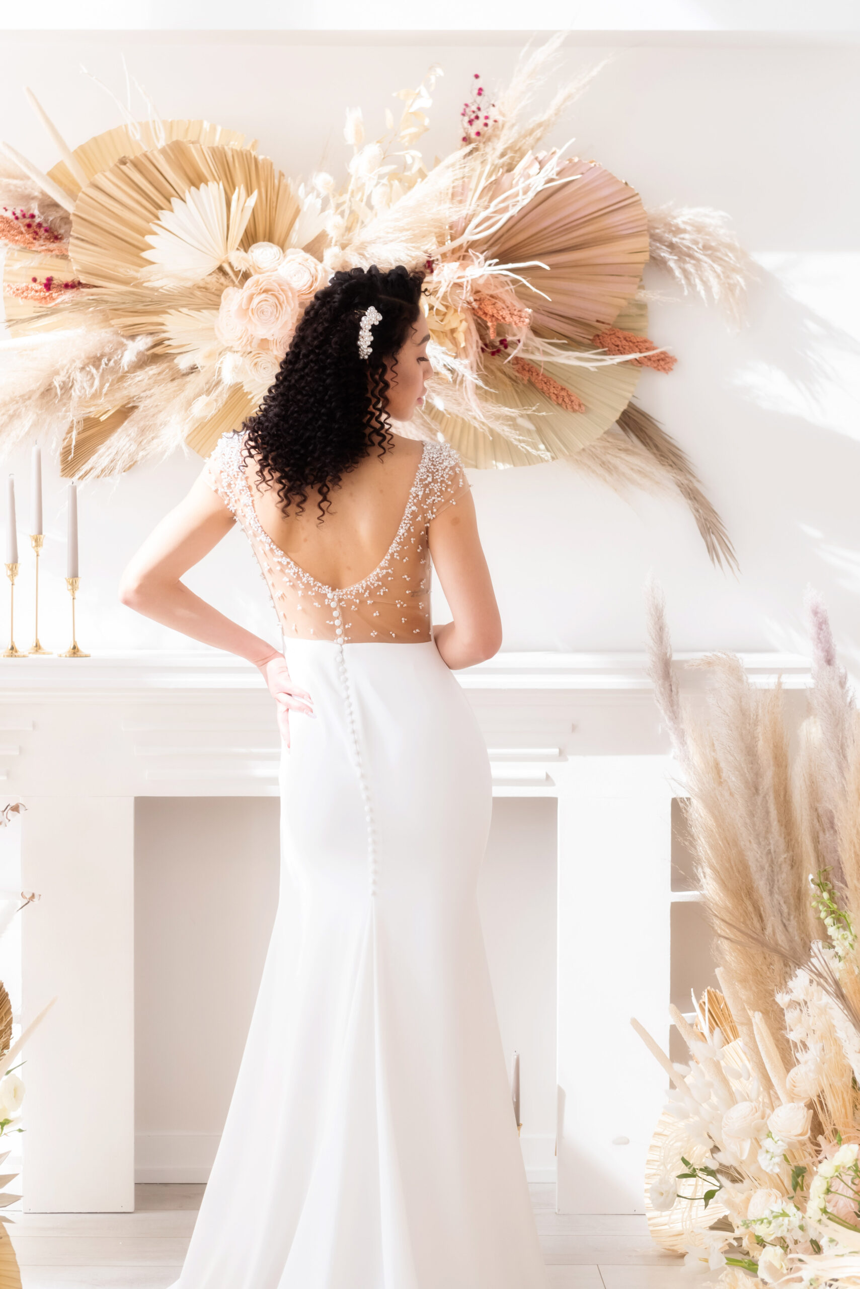 Bride in modern sleeveless wedding gown with sexy low back and illusion pearl details in all white wedding venue