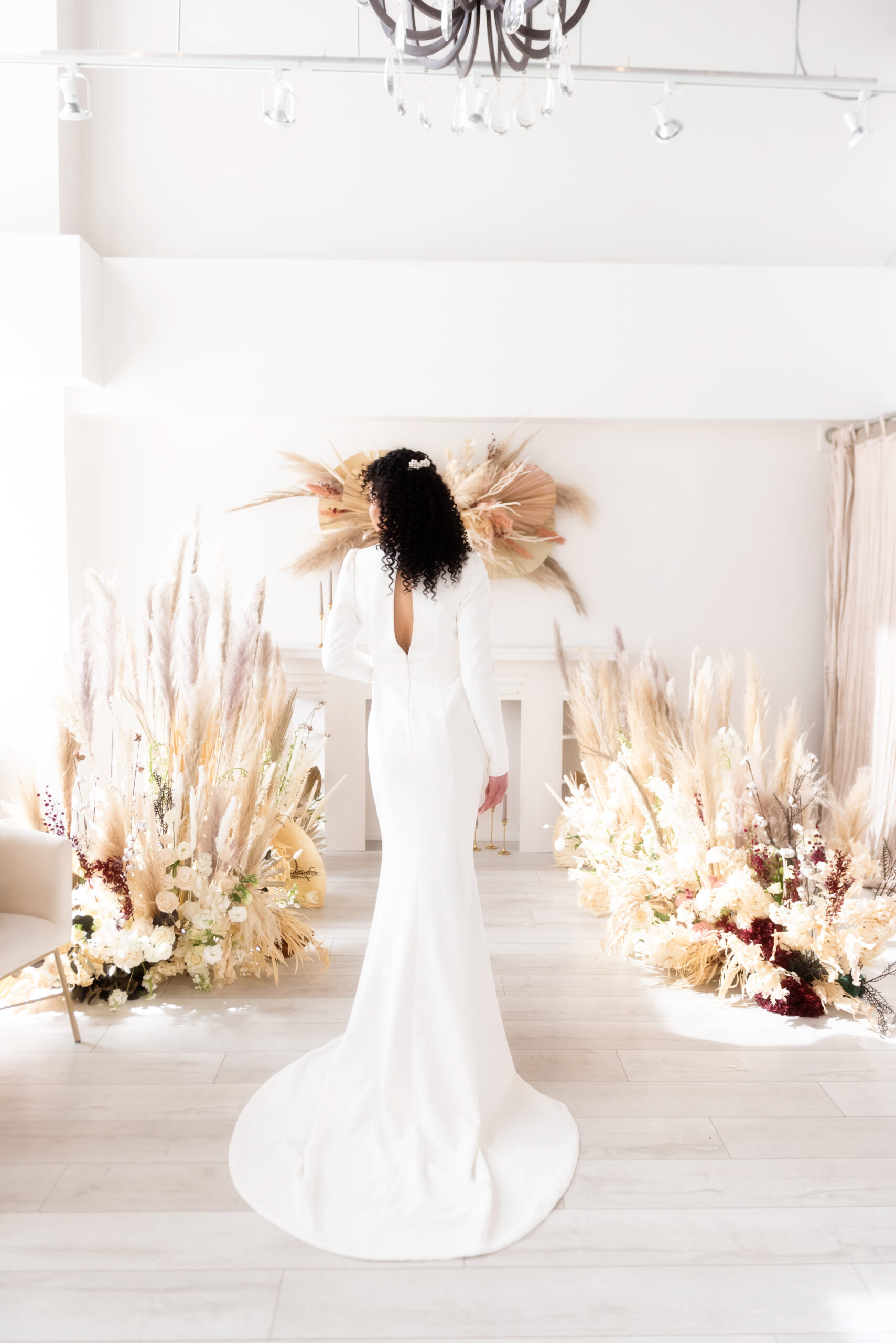 Back of bride ride in modern wedding gown with keyhole neckline and boho decor in cream and ivory