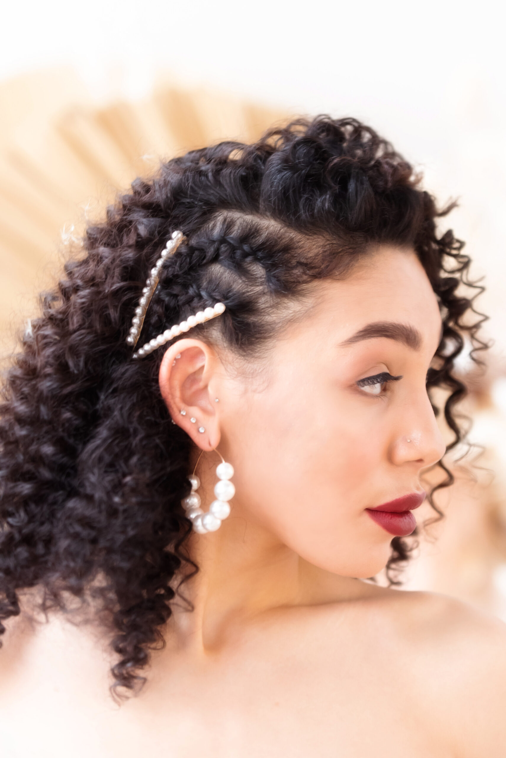 Bride with natural curls, pearlized hair clips and dramatic red lips