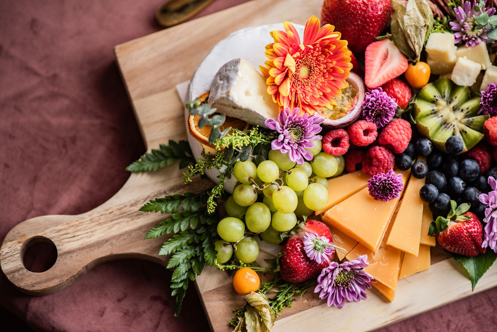 Charcuterie board with grapes and flowers