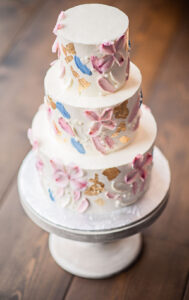 Three tier wedding cake with blue, pink and peach floral wedding decor