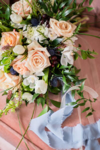 Peach and white wedding bouquet with powder blue ribbon