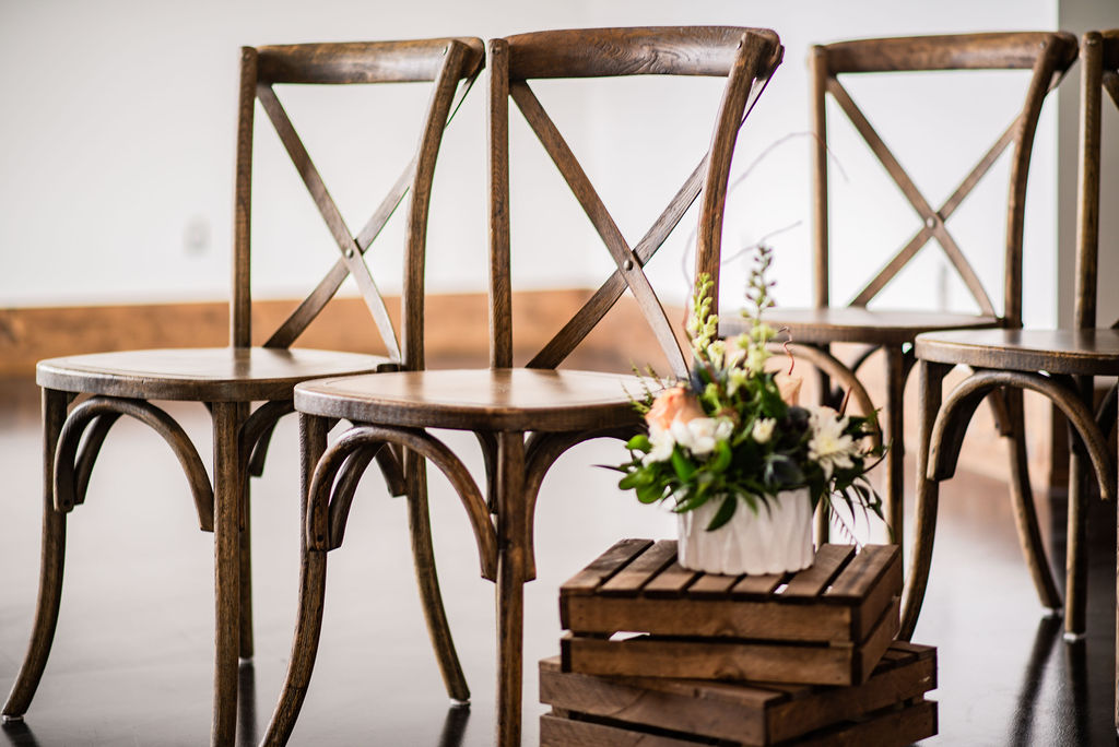Vintage brown ceremony chairs with small vintage inspired wedding arrangement