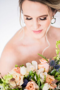 Classic wedding makeup, smokey eye, with peach and white wedding bouquet