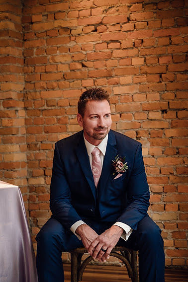 Groom in cobalt blue suit and pink tie