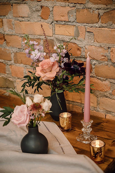 Blush and burgundy wedding flowers in black vases with gold and blush accents