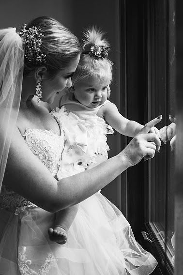 Bride holding little girl before wedding