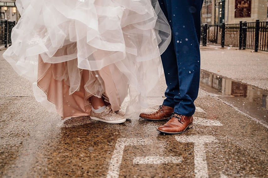 Bride's wedding shoes under ruffled ballgown skirt