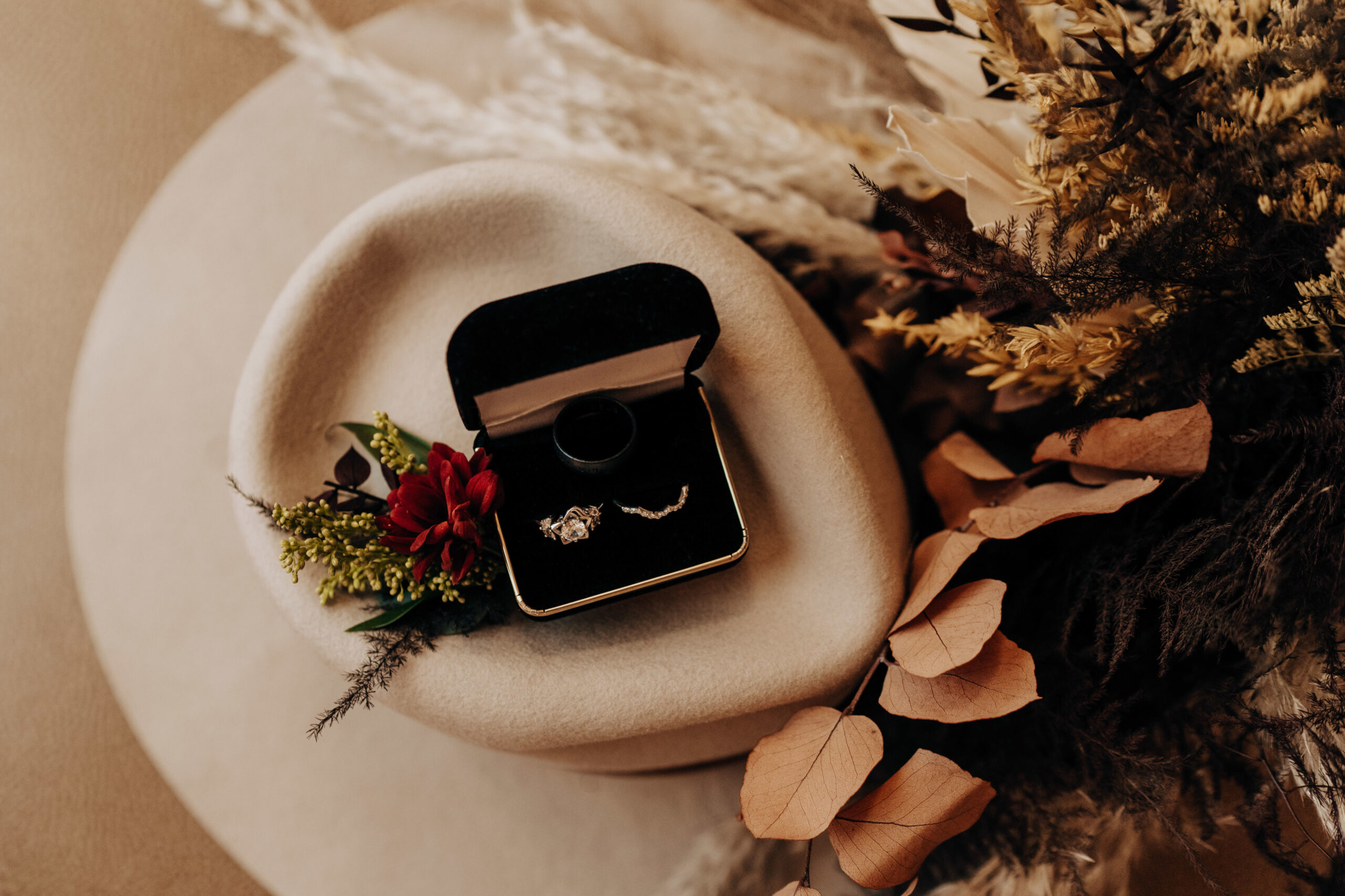 Wedding rings in dark blue ring box on ivory background