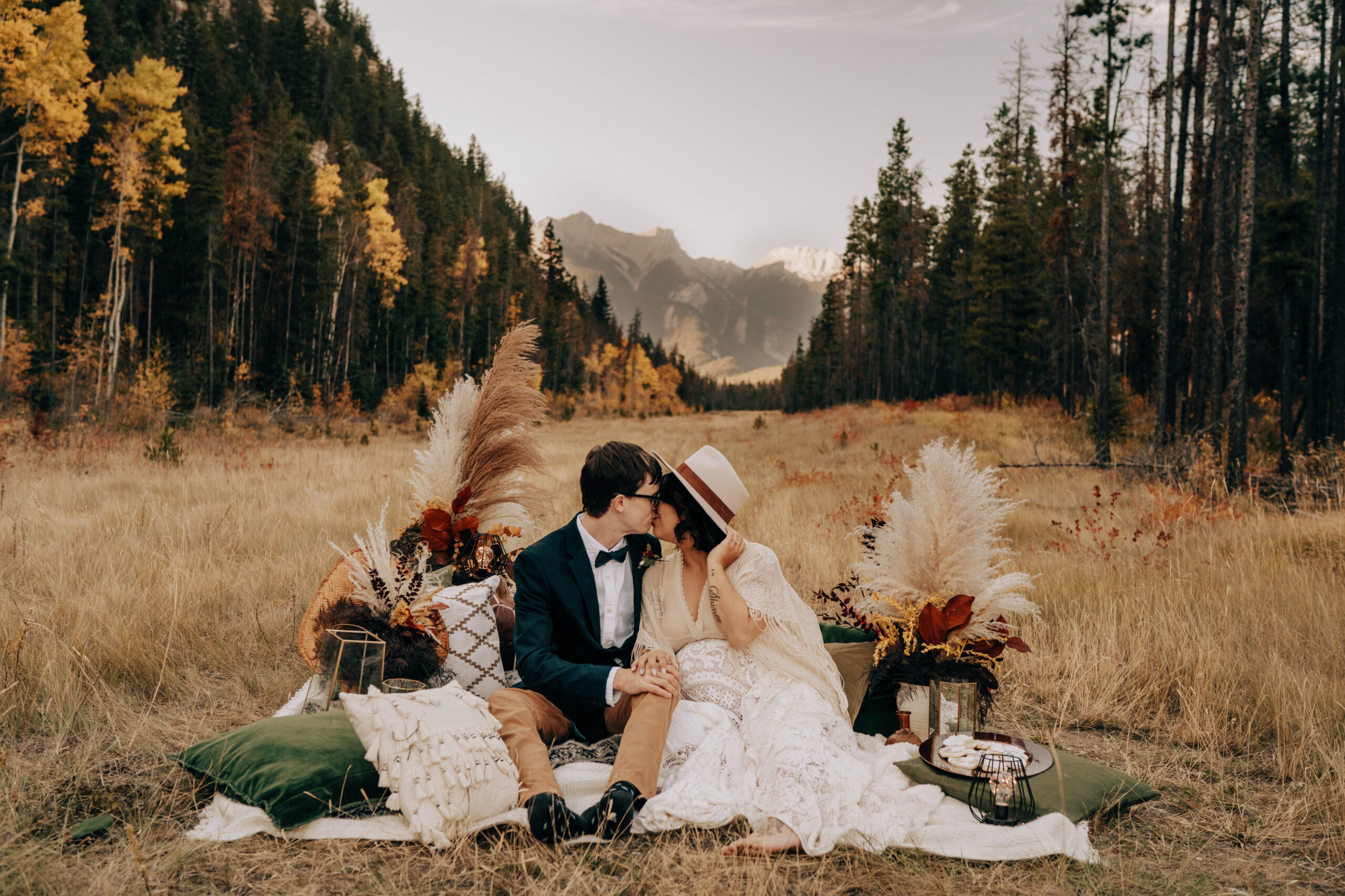 Boho couple with boho wedding decor in valley in forest