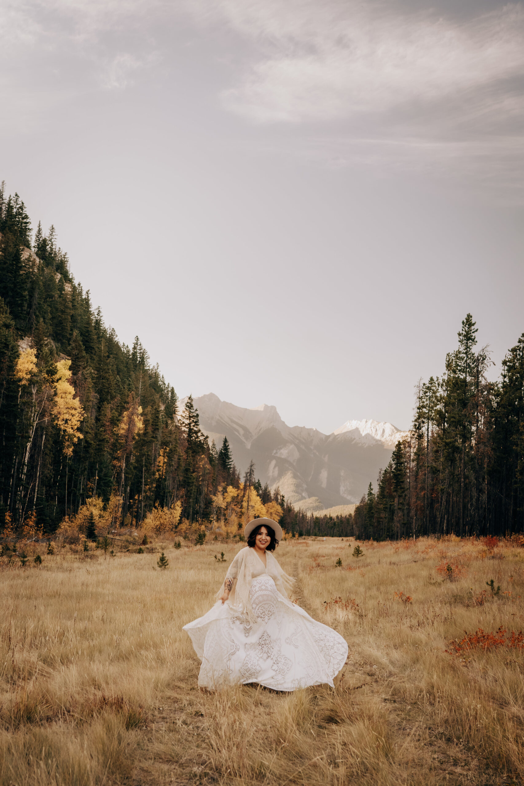 Boho bride dancing in valley in the forest