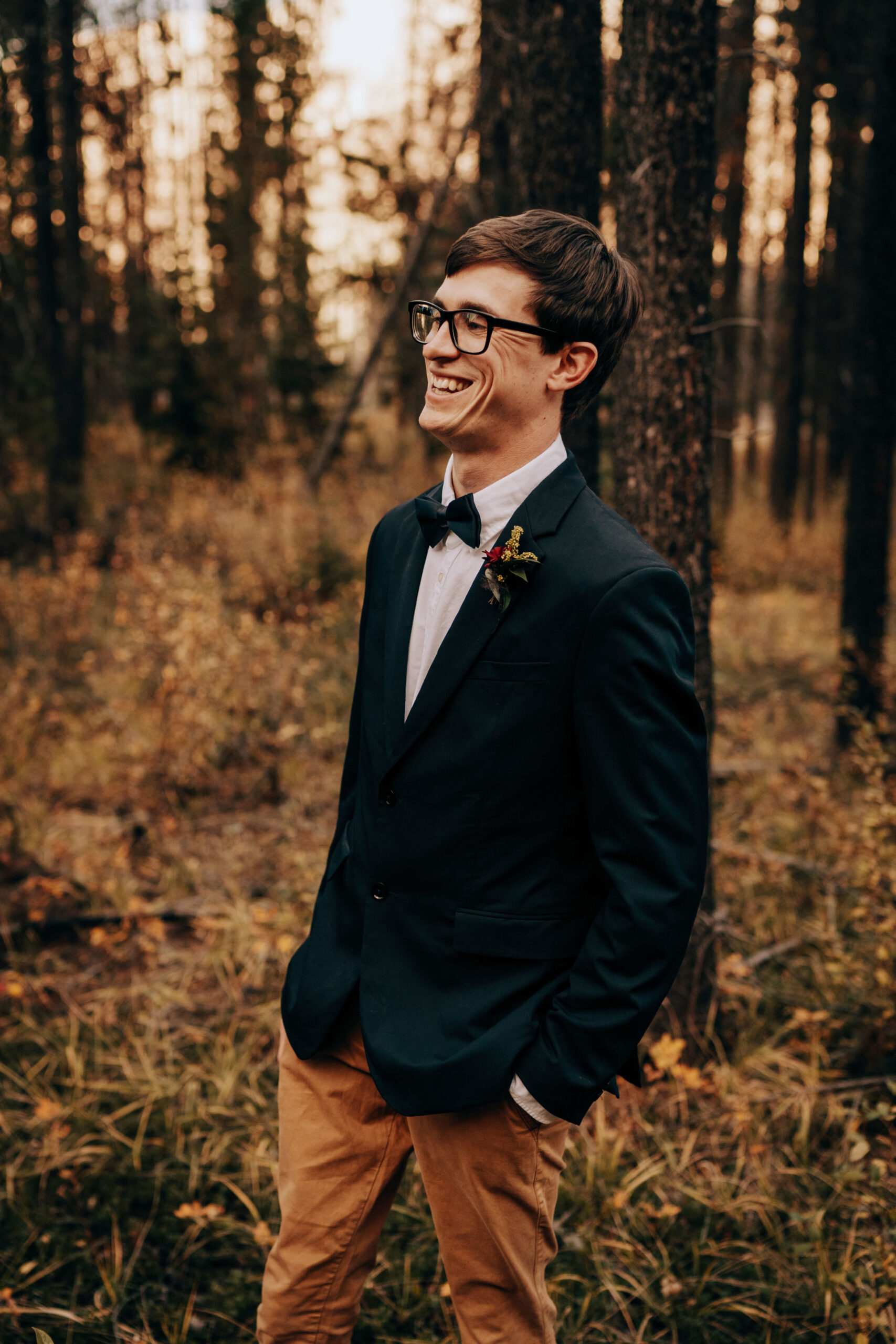 Groom in dark suit jacket and tan pants with bowtie