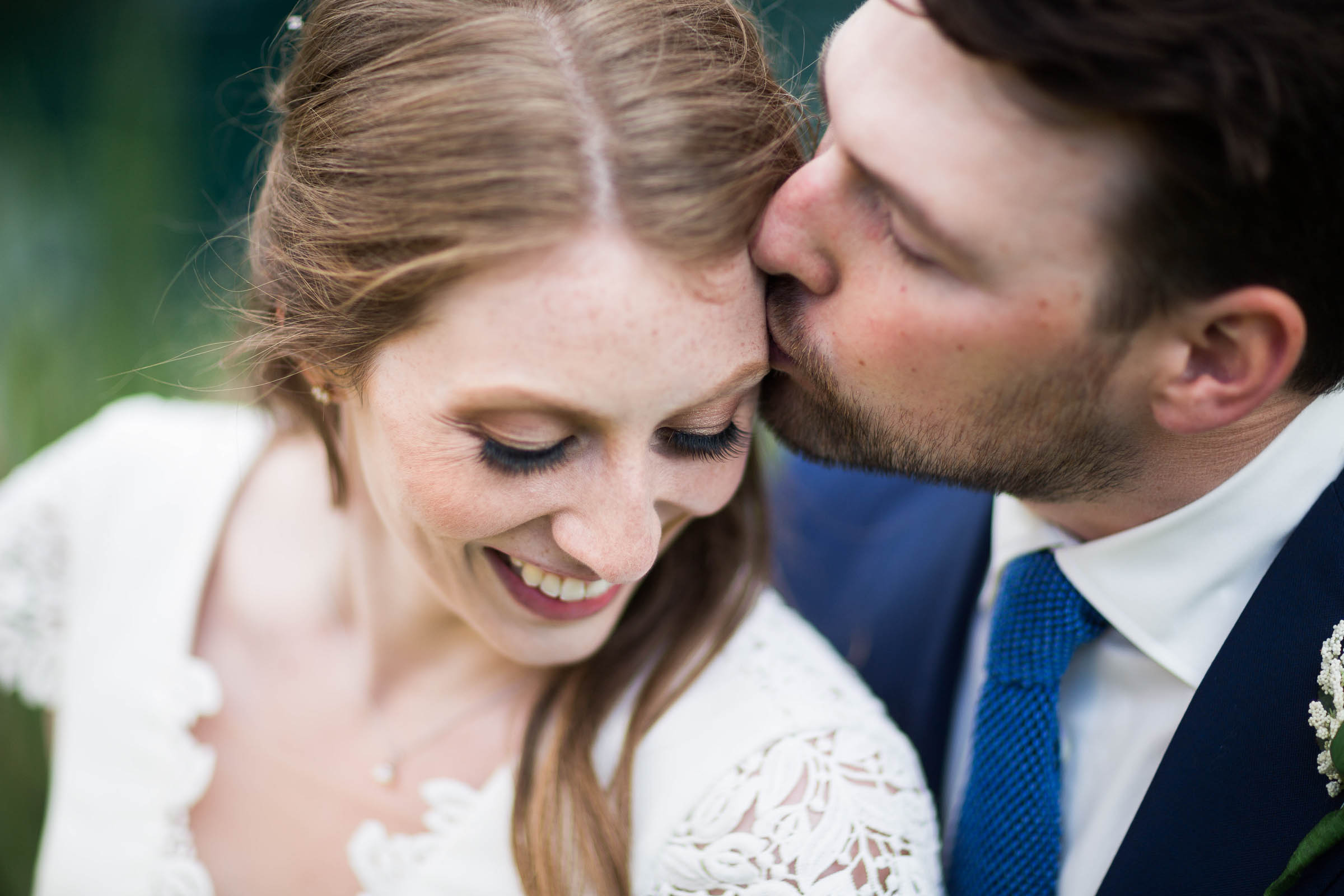 Groom softly kissing bride after wedding ceremony