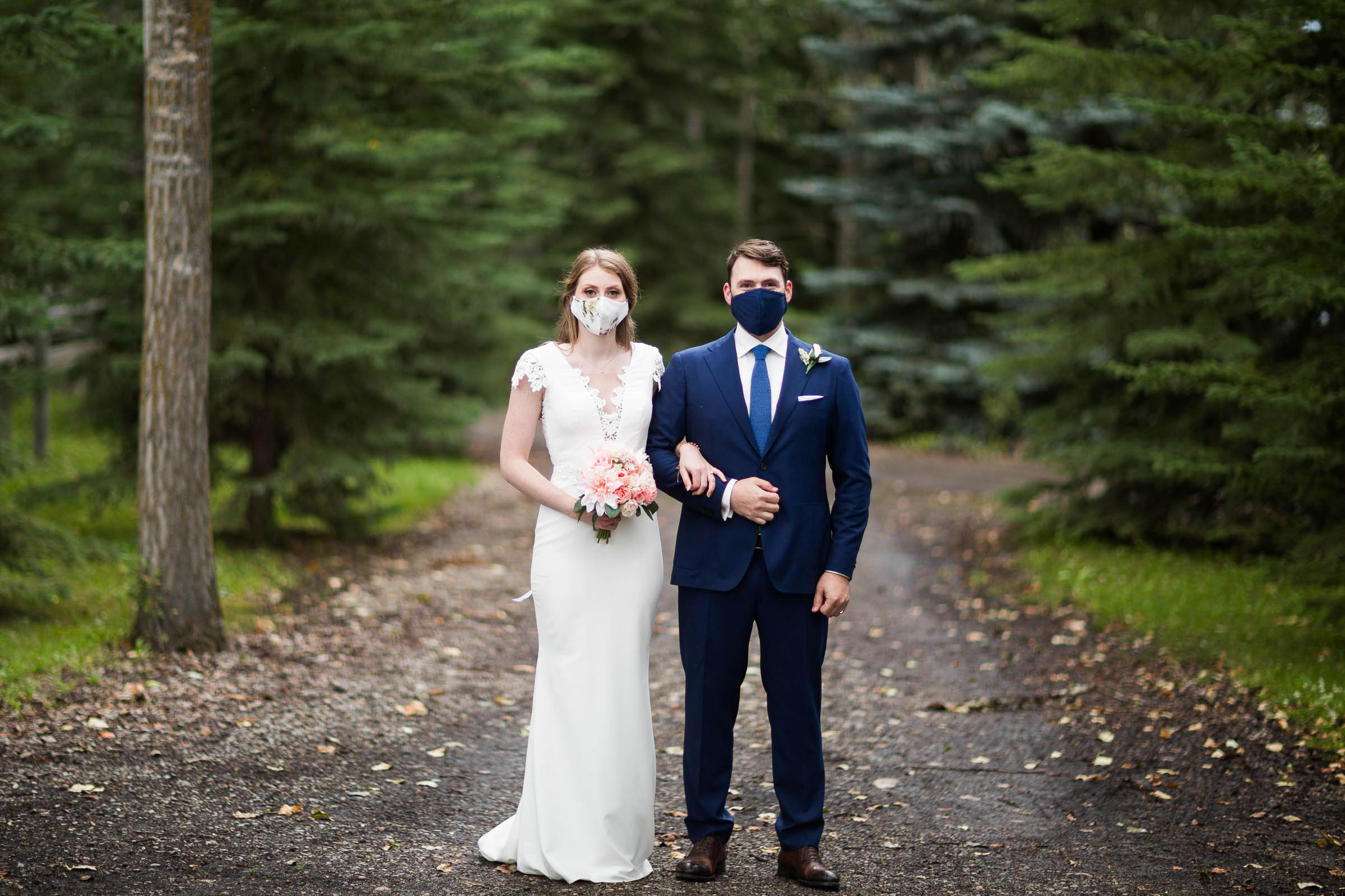 Couple wearing wedding masks in forest setting