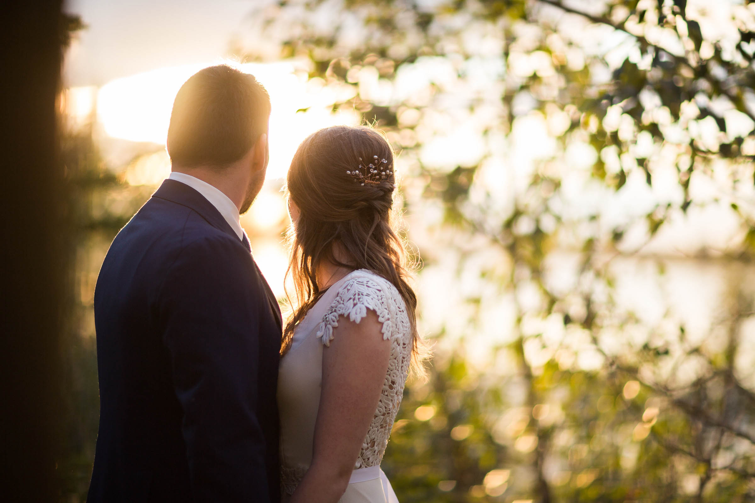 Bride and groom looking into late evening sunset