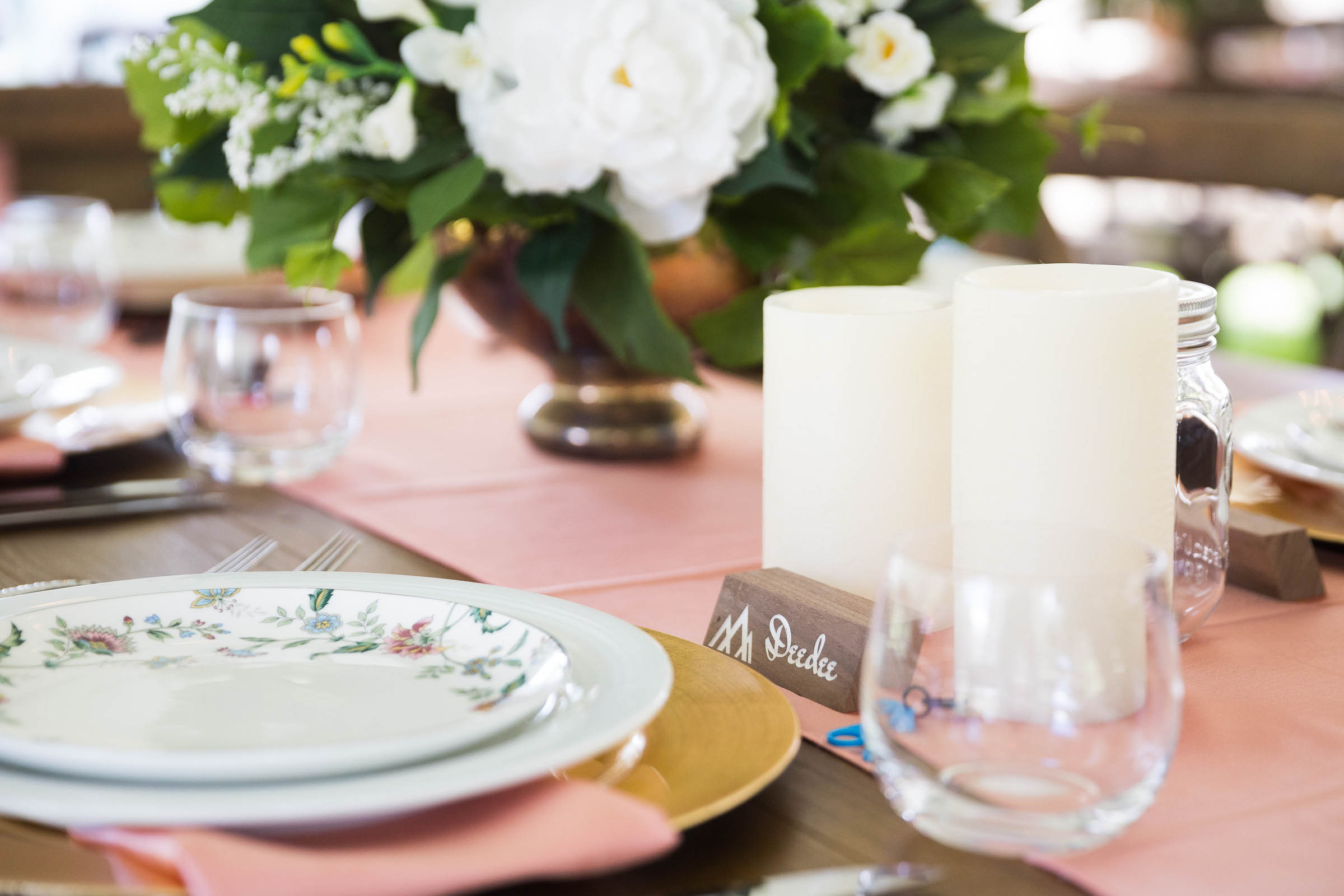 Rustic romantic wedding decor place setting with vintage plate with floral design and pink table runner