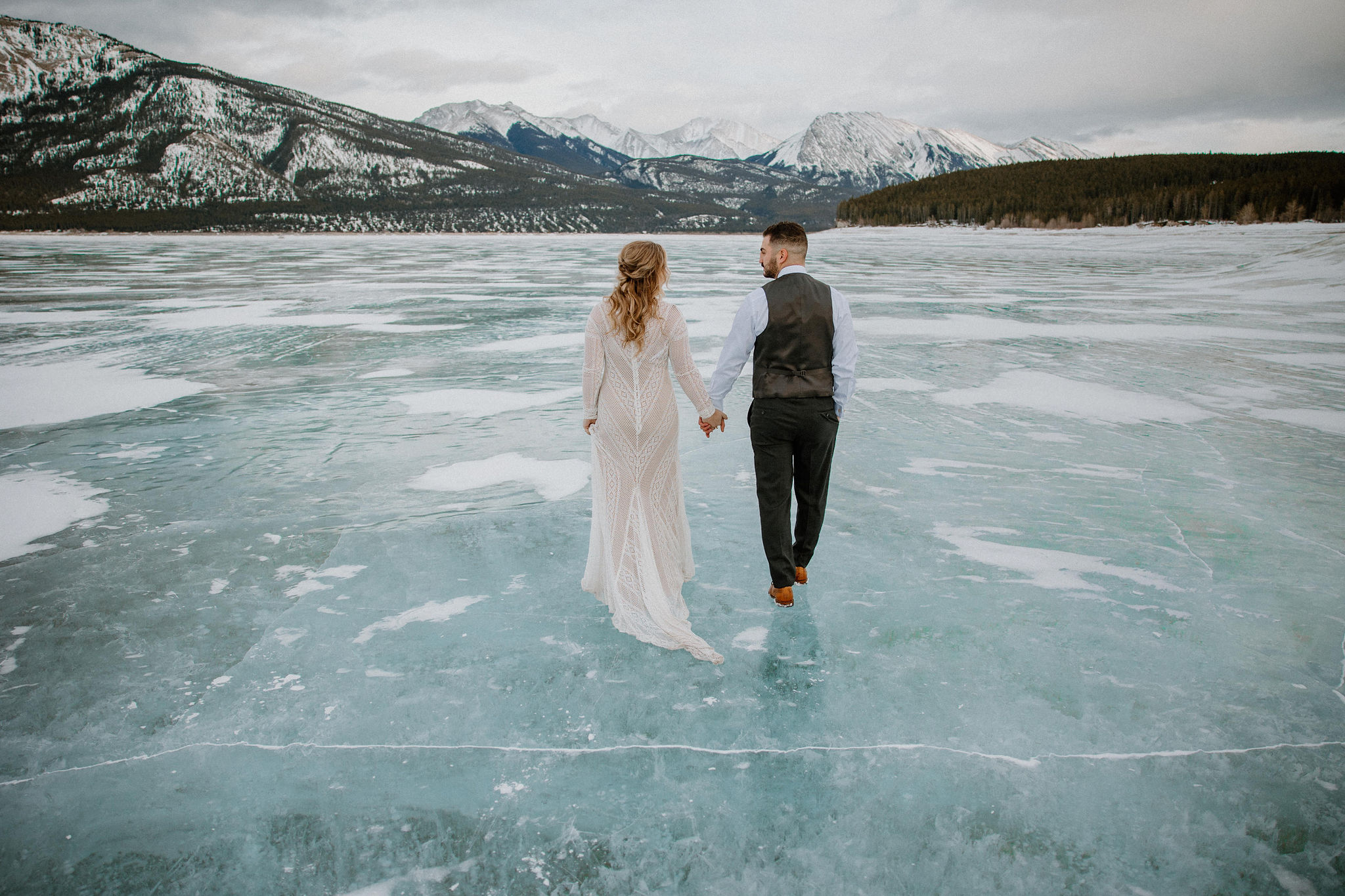 Couple in wedding formal walking on frozen lake