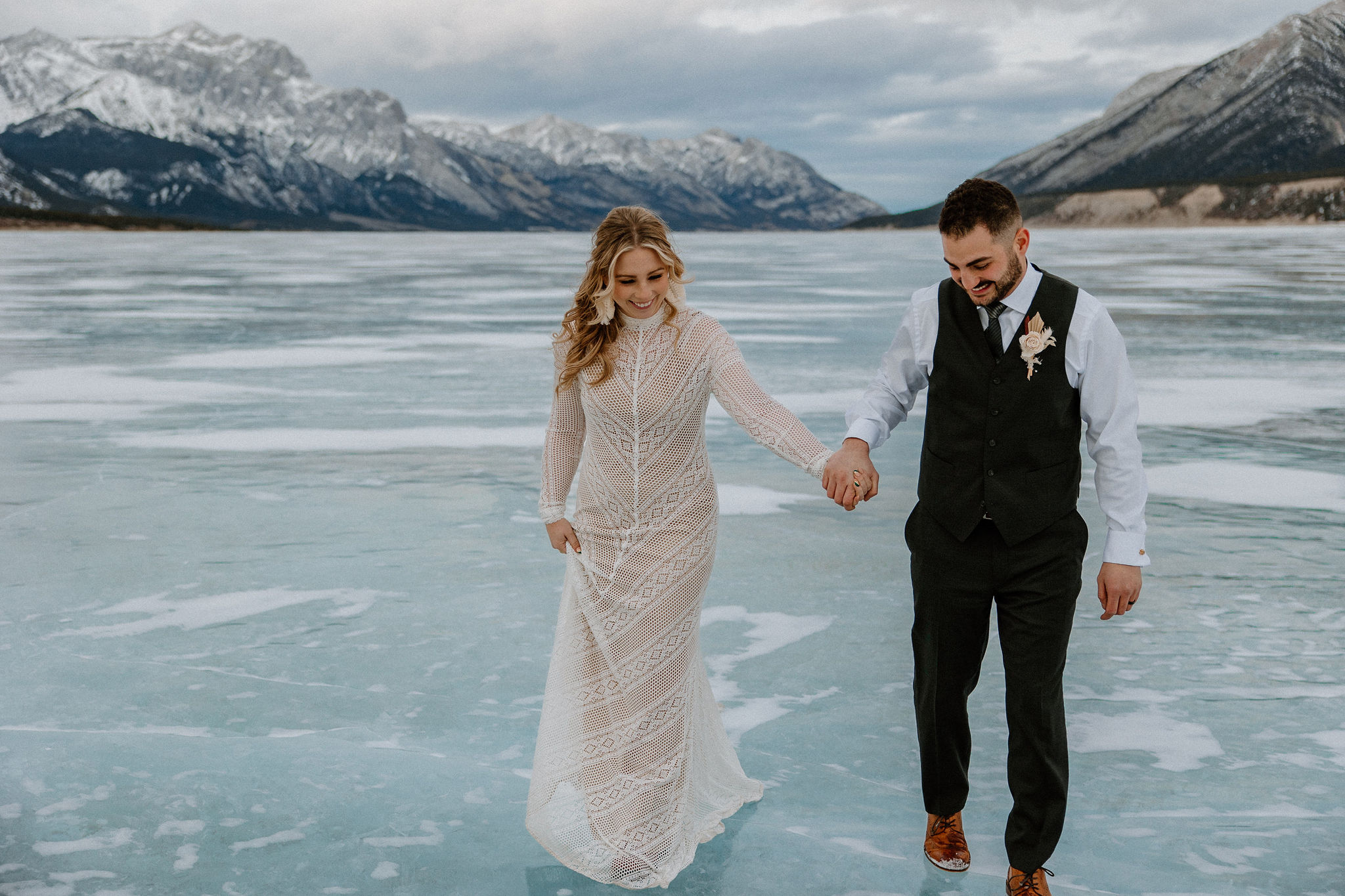 Couple in wedding formal walking on frozen lake