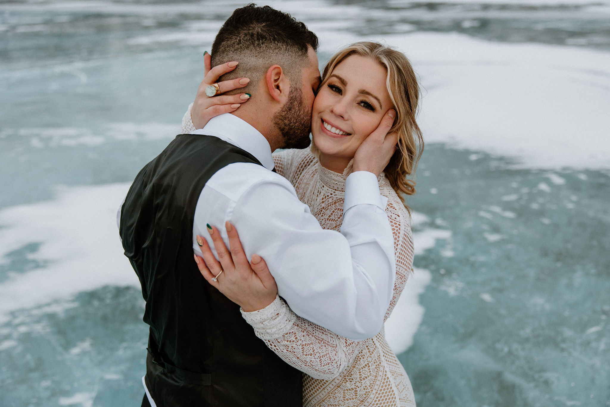 Couple in wedding formal hugging on frozen lake